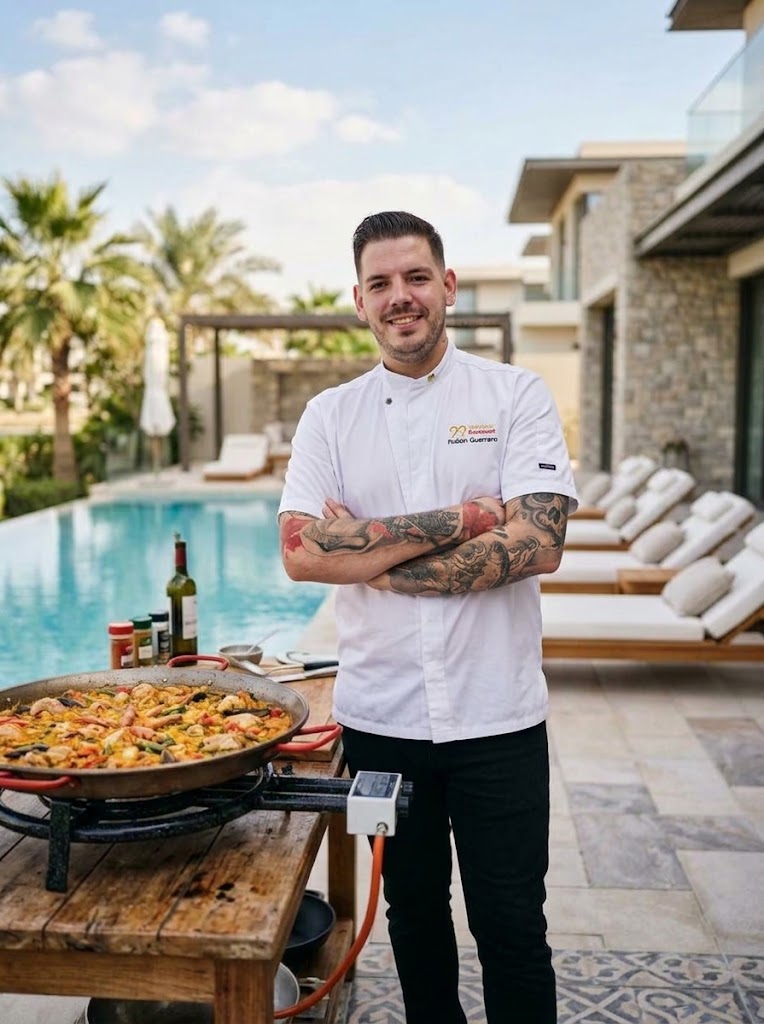 Portrait of Spanish Executive Chef Rubén Guerrero Simón beside his live paella station in Dubai